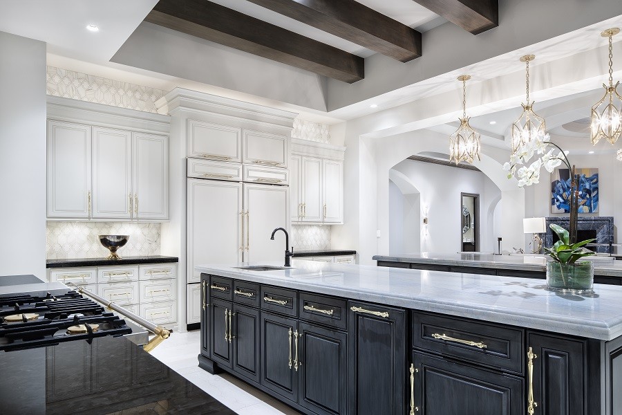 Modern luxury kitchen with marble countertops and stylish cabinets dramatically illuminated with Ketra Lighting. 