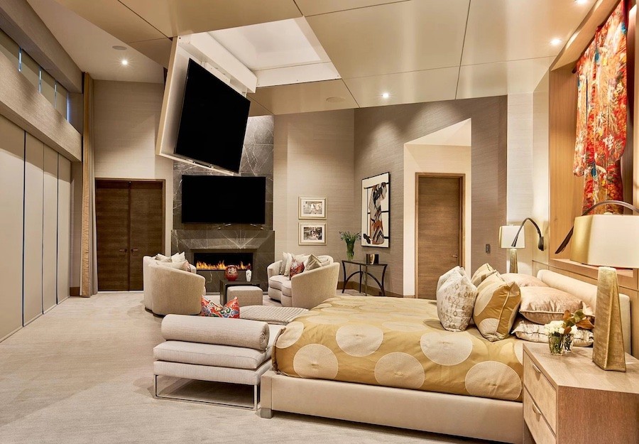 Bedroom with a large-screen TV that folds down from a ceiling panel above the foot of the bed.