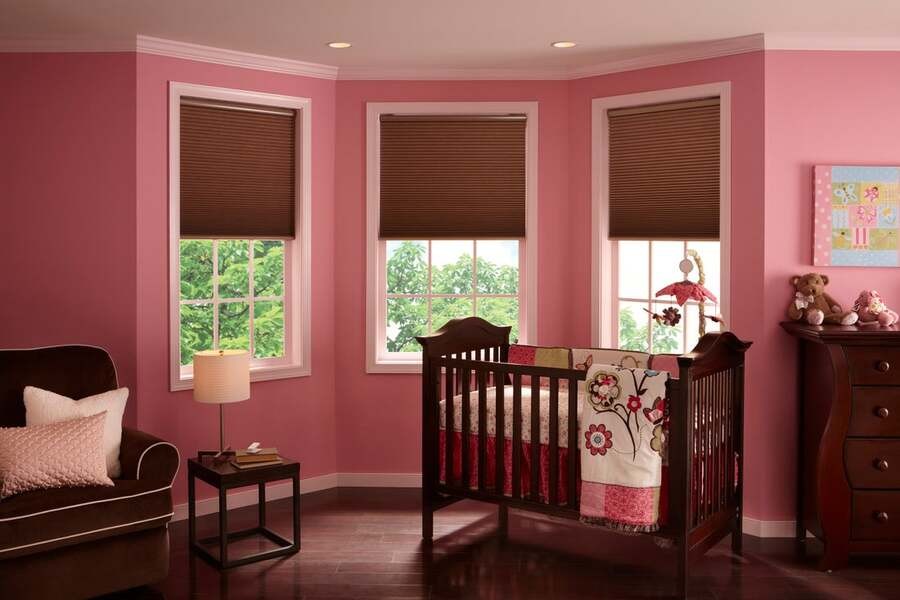 A pink nursery room with Lutron shades.